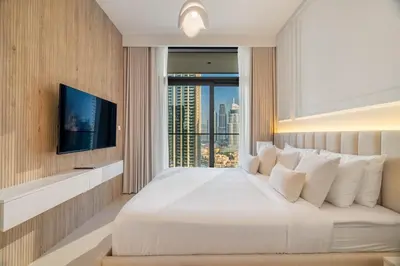 a bedroom with a large bed with a large window at Luxurious 4BR with Boulevard View - 10 min to Burj & Mall in Dubai