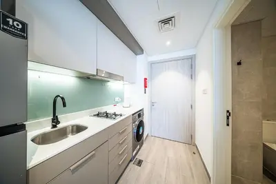 a kitchen with a sink and a washing machine at Studio in Dubai Production City in Dubai