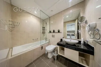 a bathroom with a sink and a tub and a toilet at Damac Hills - Artecia Tower, Dubai in Dubai