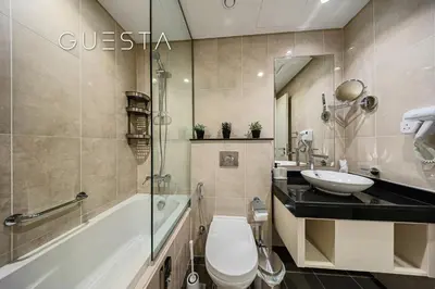a bathroom with a tub and a toilet and a sink at Damac Hills - Artecia Tower, Dubai in Dubai