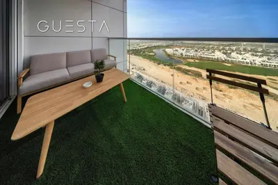 a living room with a couch and a view of the beach at Damac Hills - Artecia Tower, Dubai in Dubai