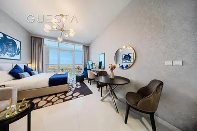 a hotel room with a bed and a table and chairs at Damac Hills - Artecia Tower, Dubai in Dubai