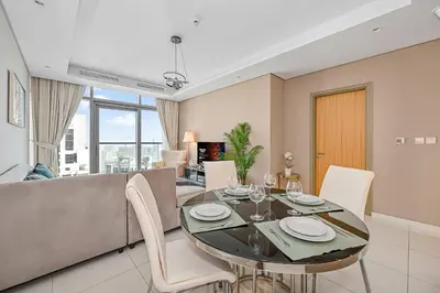 a dining room and living room with a table and chairs at Amazing 2 Bed Burj views in Dubai