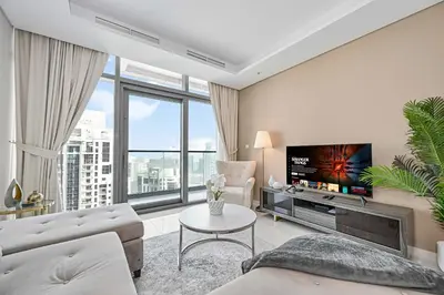 a living room with a couch and a tv at Amazing 2 Bed Burj views in Dubai