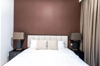 a bedroom with a large white bed with two lamps at Creek palace residence by Hogar in Sabkhah