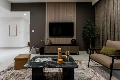 a living room with a table and a tv at Creek palace residence by Hogar in Sabkhah