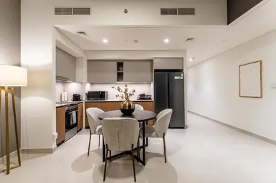 a kitchen and dining room with a table and chairs at Creek palace residence by Hogar in Sabkhah