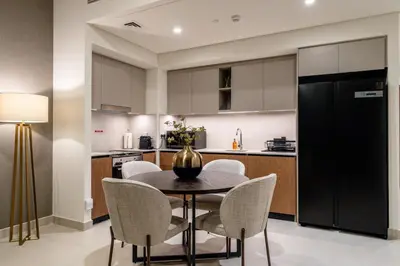 a kitchen and dining room with a table and chairs at Creek palace residence by Hogar in Sabkhah