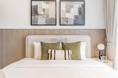 a bedroom with a white bed with three pictures on the wall at 2BR with Marina View, Walking Distance to Marina Mall, Metro Station & JBR Beach, Al Majara 1, Dubai Marina by Deluxe Holiday Homes in Dubai