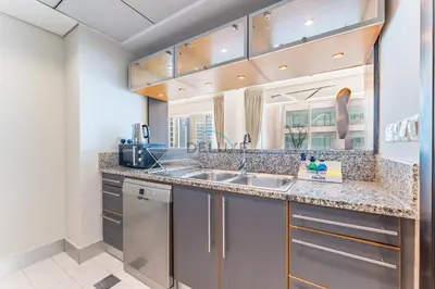 a kitchen with a sink and a counter at 2BR with Marina View, Walking Distance to Marina Mall, Metro Station & JBR Beach, Al Majara 1, Dubai Marina by Deluxe Holiday Homes in Dubai