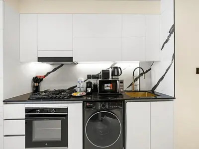 a kitchen with a stove and a washing machine at Premium Studio Private Jacuzzi Canal View in Dubai