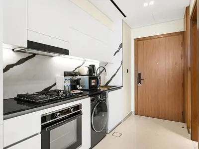 a kitchen with a stove and a washer and dryer at Premium Studio Private Jacuzzi Canal View in Dubai
