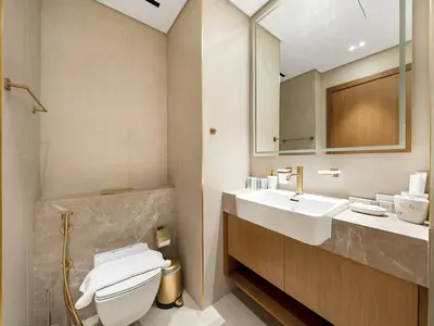a bathroom with a sink and a toilet and a mirror at Premium Studio Private Jacuzzi Canal View in Dubai