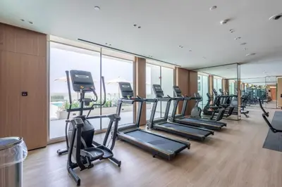 a gym with rows of treadmills and elliptical machines at Ahlan HH - Brand New Summer Suite, Near Circle Mall in Dubai