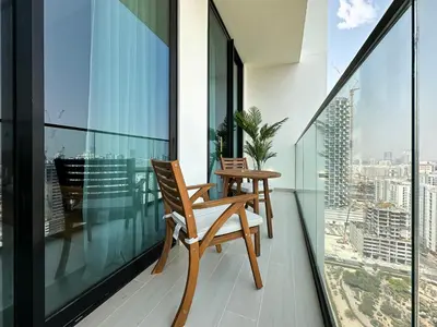 two chairs on a balcony with a view of the city at Feel at Home Stylish 1BR in Binghatti Tulip Dubai in Dubai