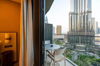 a balcony with a table and chairs and a view of a city at Venetian - Signature 3BR with Burj Khalifa & Fountain views in Dubai