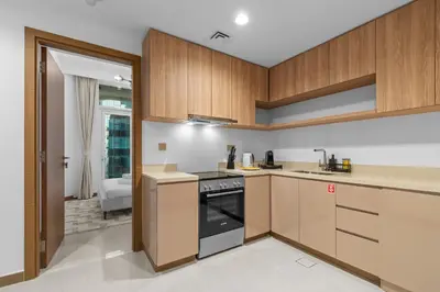 a kitchen with wooden cabinets and a stove at Modern apartment in a prime location in Dubai! in Dubai