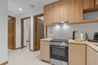 a kitchen with wooden cabinets and a stove top oven at Modern apartment in a prime location in Dubai! in Dubai