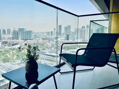 a chair and a table in front of a window at Modern 1br In Jvc Balcony Pool Free Parking in Dubai