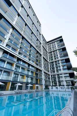 a large apartment building with a swimming pool at Modern 1br In Jvc Balcony Pool Free Parking in Dubai