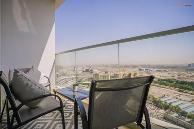 a balcony with a table and chairs and a view of a city at Bnbeyond's Modern Marina Pad in Dubai