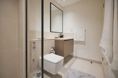 a bathroom with a toilet and a sink and a mirror at Spacious 1BR Burj Crown Downtown in Dubai