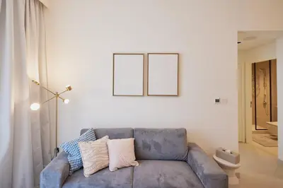 a living room with a blue couch and two frames on the wall at Spacious 1BR Burj Crown Downtown in Dubai
