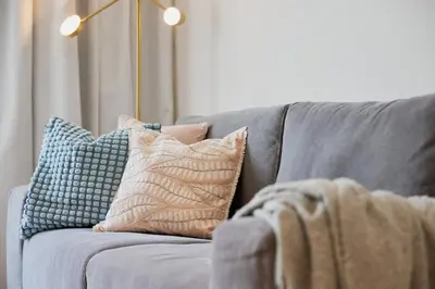 a gray couch with pillows on top of it at Spacious 1BR Burj Crown Downtown in Dubai
