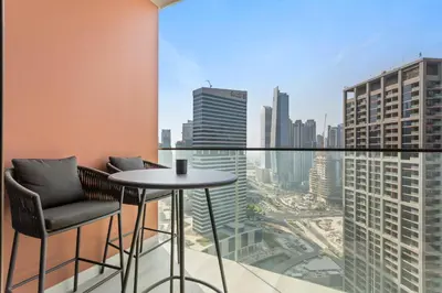 a balcony with a table and chairs and a city skyline at Designer Studio w Burj Khalifa view in Peninsula in Dubai