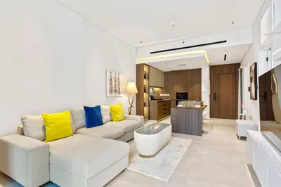 a living room with a white couch and yellow pillows at Chic Retreat 1Bedroom with Pool view in Dubai
