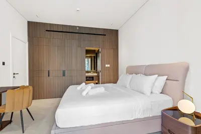 a bedroom with a large white bed and a desk at Chic Retreat 1Bedroom with Pool view in Dubai