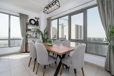a dining room with a table and chairs and large windows at Downtown Luxury 1 Bed with City Skyline Views in Dubai