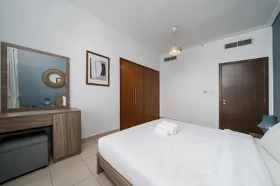 a bedroom with a bed and a dresser and a mirror at Downtown Luxury 1 Bed with City Skyline Views in Dubai