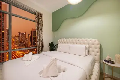 a bedroom with a white bed with a large window at Serene Cozy 2BR Near Burj Khalifa in Dubai