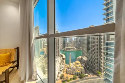 a room with a large window with a view of the city at Cityscape & Coastal Charm Elegant 2BR Seaside in Dubai Marina