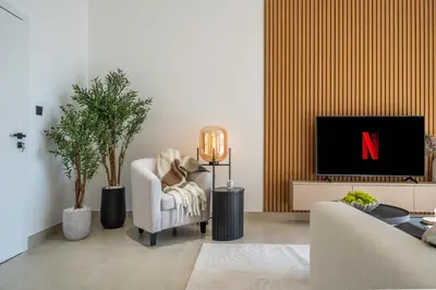 a living room with a tv and a couch and a chair at High-Floor 1BR New Design Steps to JBR Beach in Dubai