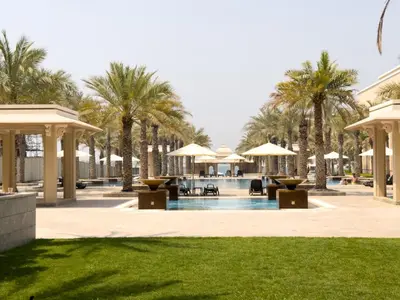 a resort pool with palm trees and umbrellas at Luxury 2BR plus Maidrm at Grandeur Res Palm Jumeir in Dubai
