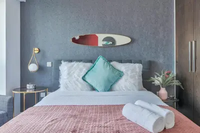 a bedroom with a bed with a pink blanket and blue pillows at 65th Floor Penthouse Dubai Marina in Dubai
