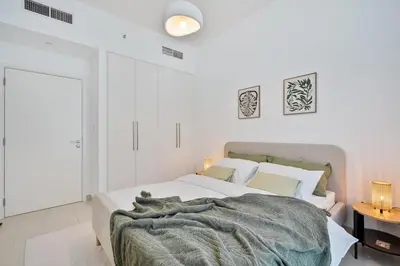 a white bedroom with a bed and a table at Venetian - Wake up to Burj Khalifa views in Downtown Dubai in Dubai
