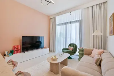 a living room with a couch and a tv at Venetian - Wake up to Burj Khalifa views in Downtown Dubai in Dubai