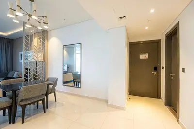 a dining room and living room with a table and chairs at Venetian - Luxe Living 1 BR with Stunning Sky Line Views in Dubai