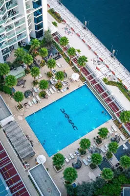 an overhead view of a swimming pool with chairs and a beach at Venetian - Luxe Living 1 BR with Stunning Sky Line Views in Dubai
