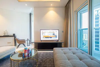 a living room with a couch and a tv at Venetian - Luxe Living 1 BR with Stunning Sky Line Views in Dubai