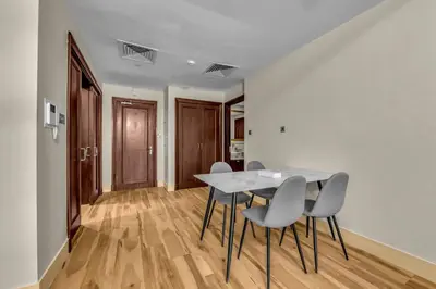 a dining room with a white table and chairs at Front Burj Khalifa 2BR in Old town community in Dubai
