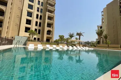 a swimming pool with lounge chairs and buildings at HAVN - 1 Bedroom in Madinat Jumeirah Living in Dubai
