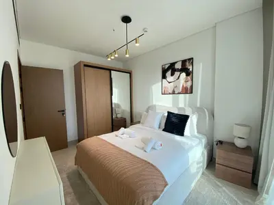 a bedroom with a large bed with two towels on it at Modern & Cozy 1 Bedroom Apartment in JVC 215-GLX-1 in Dubai