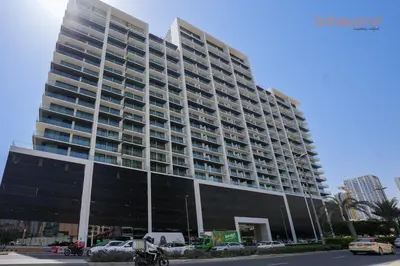 a large building with cars parked in front of it at Bnbeyond's Chic Urban Retreat with Upscale 1BR in Dubai
