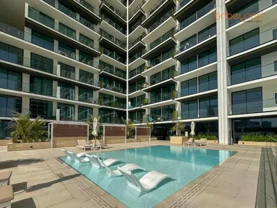 a swimming pool in front of a large building at Bnbeyond's Chic Urban Retreat with Upscale 1BR in Dubai