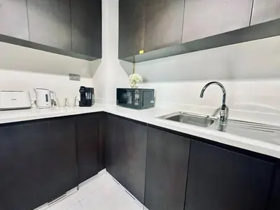 a kitchen with black and white cabinets and a sink at Stylish 1br Merano Tower Pool Parking in Dubai