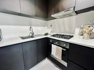 a small kitchen with a sink and a stove at Stylish 1br Merano Tower Pool Parking in Dubai
